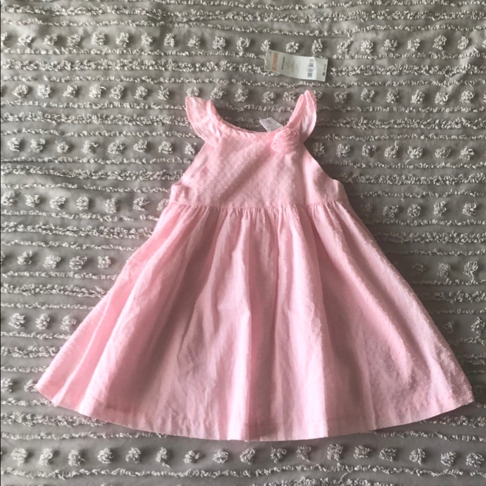 Pink dress with rose appliqué on neckline.